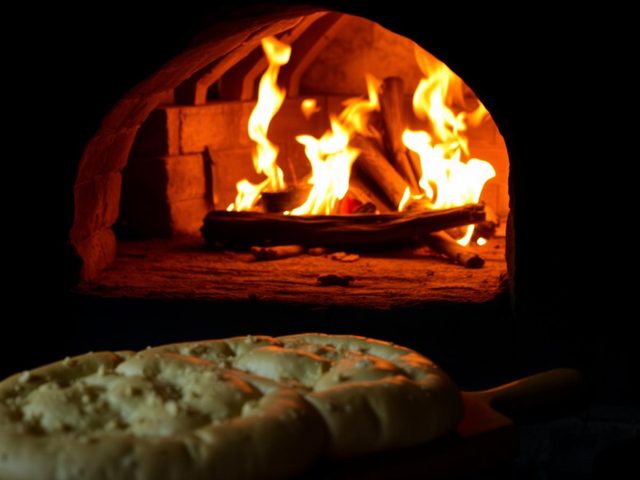 Wood-fired stone oven baking traditional pide